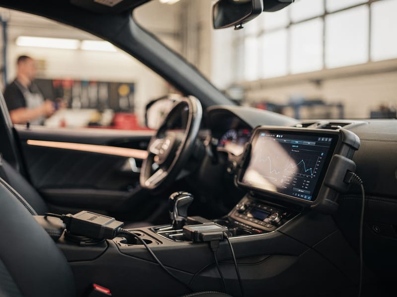 A diagnostic scan tool reading a car's live data in the bay